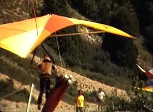 Colorful hang glider on final approach to beach landing in 1974